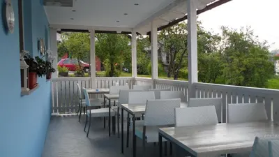a restaurant with tables and chairs on a balcony at The Blue House in Tolmin