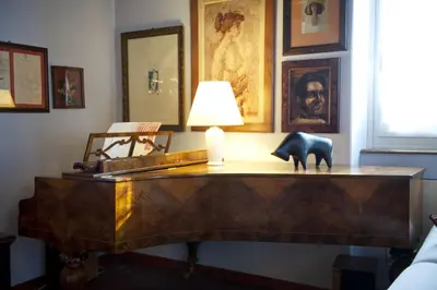 a lamp sitting on top of a wooden piano at The Blue House in Tolmin