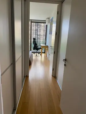 a hallway with a door open to a room with a chair at TiliaStay in Ljubljana