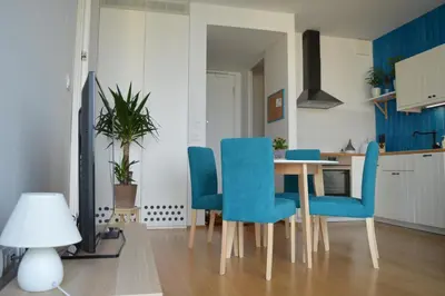 a dining room with a table and blue chairs at TiliaStay in Ljubljana