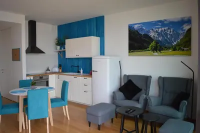 a kitchen with blue chairs and a table in a kitchen at TiliaStay in Ljubljana