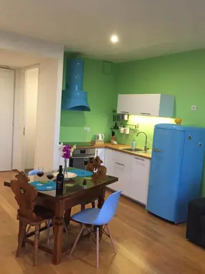 a kitchen with a table and chairs and a blue refrigerator at TiliaStay in Ljubljana