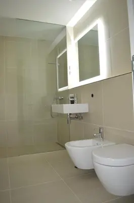 a bathroom with a sink and a toilet and a mirror at TiliaStay in Ljubljana