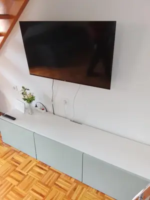 a flat screen tv hanging on a white wall at Emma's Holiday Home in Brežice
