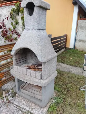 a stone oven is sitting in a yard at Emma's Holiday Home in Brežice