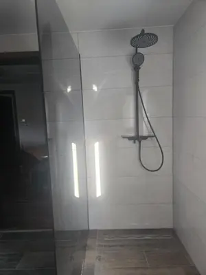 a shower in a bathroom with a glass wall at Apartmaji Beli Jelen