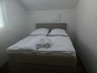 a bed with two stuffed animals on top of it at Apartmaji Beli Jelen