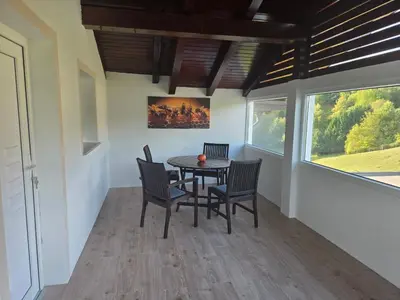 a dining room with a table and chairs and a window at Apartmaji Beli Jelen