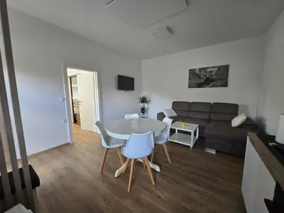 a living room with a table and a couch at Apartmaji Beli Jelen