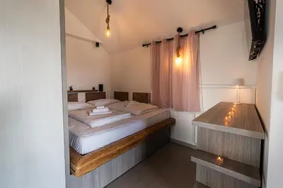a bedroom with a large bed and a desk at Hill Stars House in Straža