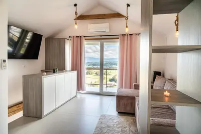 a bedroom with a bed and a large window at Hill Stars House in Straža