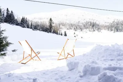 two chairs sitting in the snow at Chalet Aurora