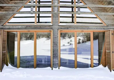 a building with glass doors in the snow at Chalet Aurora