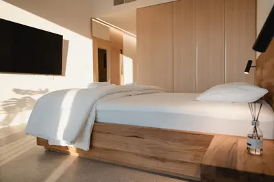 a bedroom with a bed with white sheets and a flat screen tv at Emeran Reya Estate in Šmartno