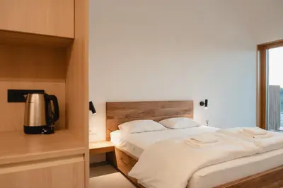 a bedroom with a bed with white sheets and a television at Emeran Reya Estate in Šmartno