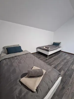 two beds sitting in a room with wooden floors at Vila Marina in Prestranek