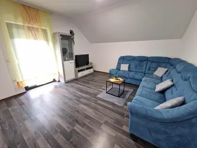 a living room with a blue couch and a television at Vila Marina in Prestranek
