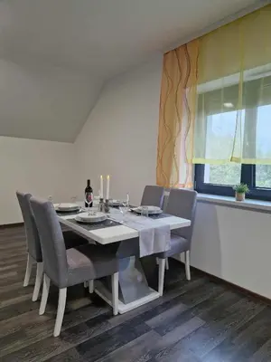a dining room with a table and chairs and a window at Vila Marina in Prestranek