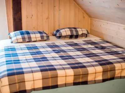 a bed in a cabin with two pillows on it at Serene Rustic Haven Holiday Home with Sauna - Two Bedroom Holiday Home with Sauna in Bistrica ob Sotli