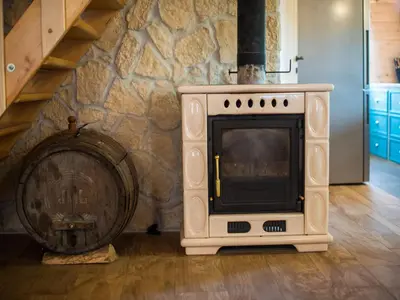 a oven and a wooden barrel next to a stone wall at Serene Rustic Haven Holiday Home with Sauna - Two Bedroom Holiday Home with Sauna in Bistrica ob Sotli