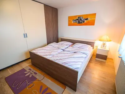 a small bedroom with a bed and a lamp at Relaxing Retreat with Hot Tub in Sevnica - Three Bedroom Apartment in Sevnica