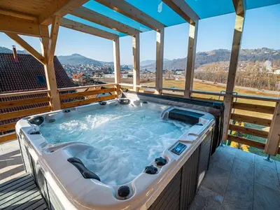 a jacuzzi tub on a deck with a view at Relaxing Retreat with Hot Tub in Sevnica - Three Bedroom Apartment in Sevnica