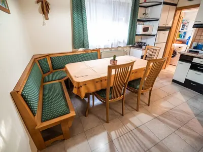 a dining room table with chairs and a kitchen at Relaxing Retreat with Hot Tub in Sevnica - Three Bedroom Apartment in Sevnica