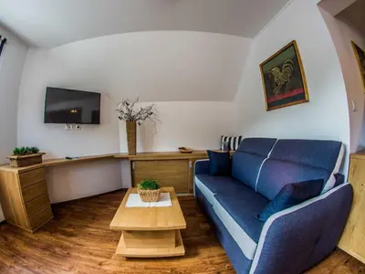 a living room with a blue couch and a table at Riverside Pines Luce Apartments with Balcony - Two Bedroom Apartment with Balcony in Luče