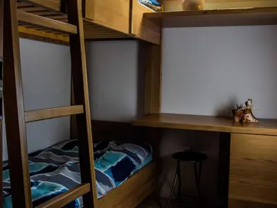 a bedroom with bunk beds with a cat sitting on a stool at Riverside Pines Luce Apartments with Balcony - Two Bedroom Apartment with Balcony in Luče