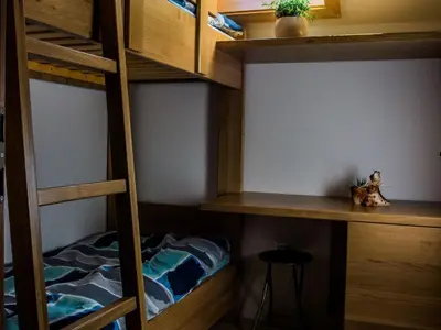 a room with bunk beds with a desk and a stool at Riverside Pines Luce Apartments with Balcony - Two Bedroom Apartment with Balcony in Luče
