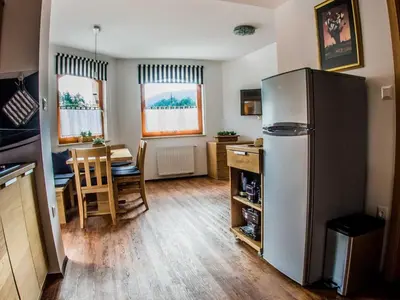 a kitchen and dining room with a refrigerator and a table at Riverside Pines Luce Apartments with Balcony - Two Bedroom Apartment with Balcony in Luče
