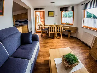 a living room with a blue couch and a table at Riverside Pines Luce Apartments with Balcony - Two Bedroom Apartment with Balcony in Luče