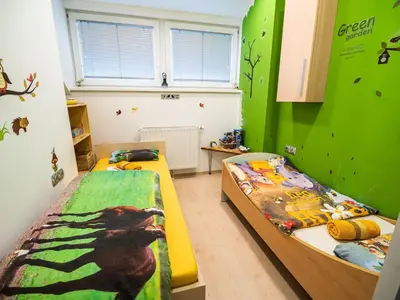 a bedroom with two beds and a green wall at Elegant and Stylish Retreat Apartments with Terrace - Three Bedroom Apartment with Terrace in Brežice