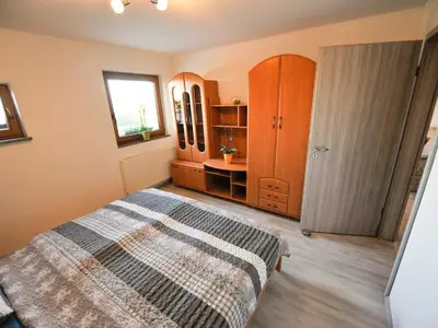 a bedroom with a bed and wooden cabinets and a window at Relax and Rustic Apartments with Terrace - Standard One Bedroom Apartment with Terrace in Brežice