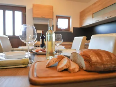 a table with a bottle of wine and a loaf of bread at Relax and Rustic Apartments with Terrace - Standard One Bedroom Apartment with Terrace in Brežice