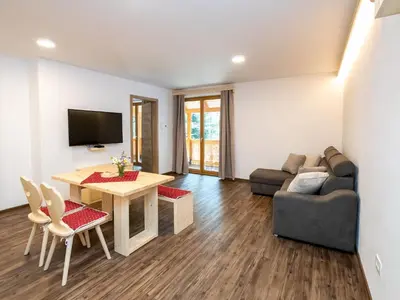 a living room with a table and a couch at The Woodland Nook Apartments Bohinj - One Bedroom Apartment with Balcony in Bohinj