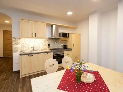 a kitchen with a table with a red and white polka dot table cloth at The Woodland Nook Apartments Bohinj - One Bedroom Apartment with Balcony in Bohinj