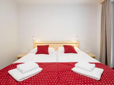a bedroom with a large bed with red and white pillows at The Woodland Nook Apartments Bohinj - One Bedroom Apartment with Balcony in Bohinj