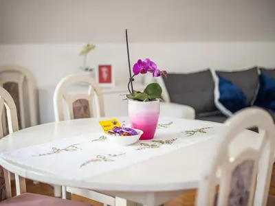 a white table with a vase with a flower on it at Mountain View Haven Apartments - One Bedroom Apartment with Balcony in Bovec