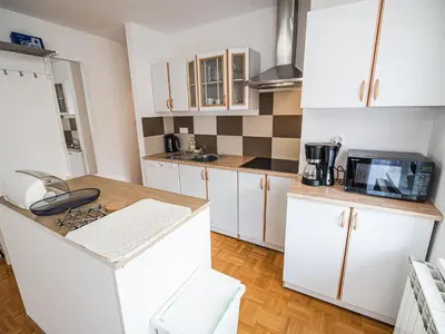 a small kitchen with white cabinets and a microwave at Mountain View Haven Apartments - One Bedroom Apartment with Balcony in Bovec