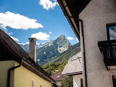 a view of a mountain from between two buildings at Mountain View Haven Apartments - One Bedroom Apartment with Balcony in Bovec