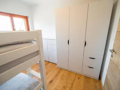 a bedroom with a bunk bed and a closet at Serene Hollow Holiday Home with Mountain View - Two Bedroom Holiday Home with Mountain View in Cerklje ob Krki