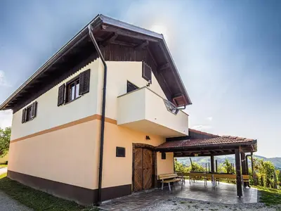 a large house with a porch and a roof at Serene Hollow Holiday Home with Mountain View - Two Bedroom Holiday Home with Mountain View in Cerklje ob Krki