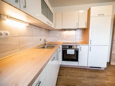 a kitchen with white cabinets and a sink at Serene Hollow Holiday Home with Mountain View - Two Bedroom Holiday Home with Mountain View in Cerklje ob Krki