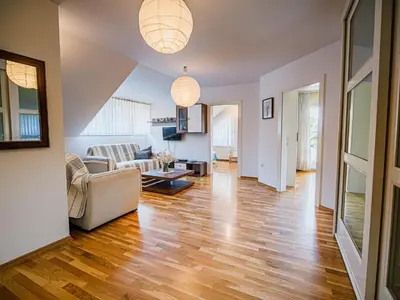 a living room with wood floors and two pendant lights at Stunning Rural Holiday Home with Garden and BBQ - Four Bedroom Holiday Home in Brežice