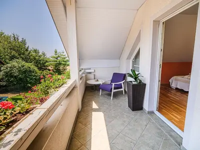 a balcony of a house with a purple chair at Stunning Rural Holiday Home with Garden and BBQ - Four Bedroom Holiday Home in Brežice