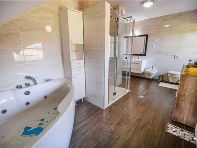 a bathroom with a tub and a shower and a toilet at Stunning Rural Holiday Home with Garden and BBQ - Four Bedroom Holiday Home in Brežice