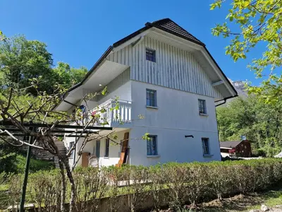 a large white building with a gambrel roof at Bovec Comfortable Apartment with Mountain View - One Bedroom Apartment with Mountain View in Bovec
