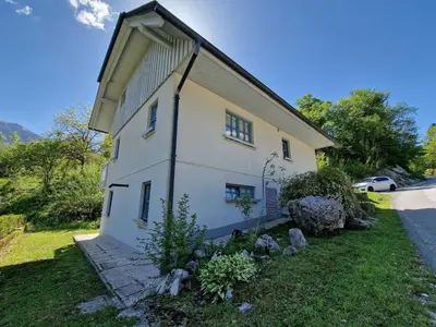 a large white building on the side of a road at Bovec Comfortable Apartment with Mountain View - One Bedroom Apartment with Mountain View in Bovec