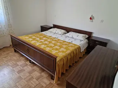 a bedroom with a large bed with a yellow blanket at Bovec Comfortable Apartment with Mountain View - One Bedroom Apartment with Mountain View in Bovec